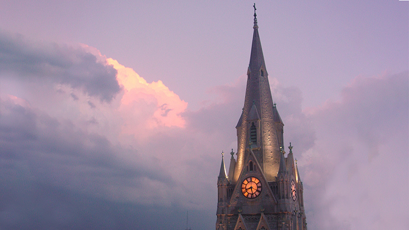 Exterior photo of church spire at dusk
